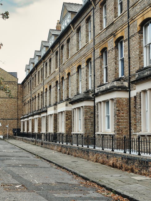 A row of traditional brick terraced houses with white-framed windows and small balconies along Westbourne Terrace. The buildings have a uniform architecture with multiple floors, and the lower level f